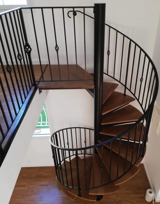 escalier en colimaçon en bois avec garde corps en fer forgé avec des détails