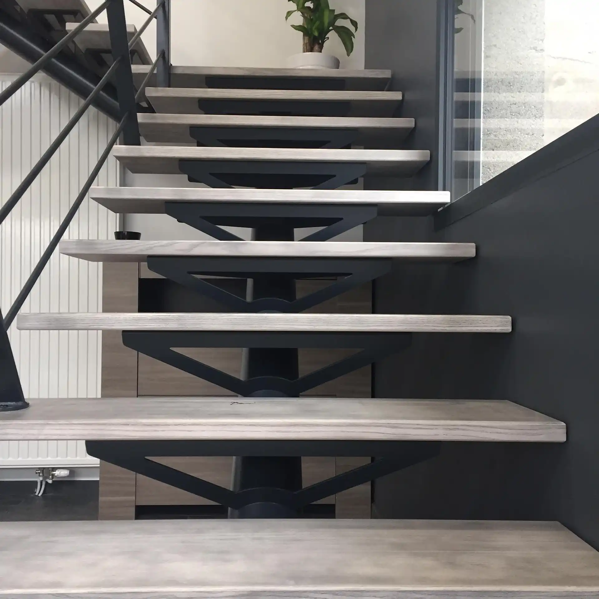Escalier suspendu sur mesure avec structure métallique noire et marches en bois