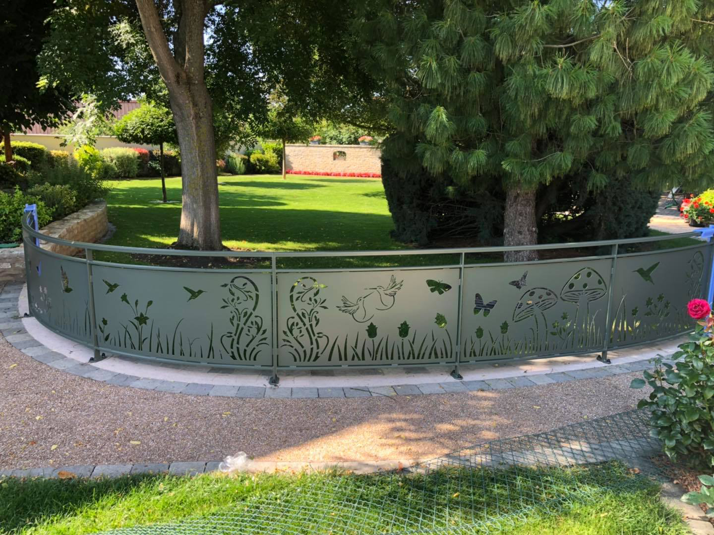 Garde-corps extérieur décoratif vert installé en séparation de jardin