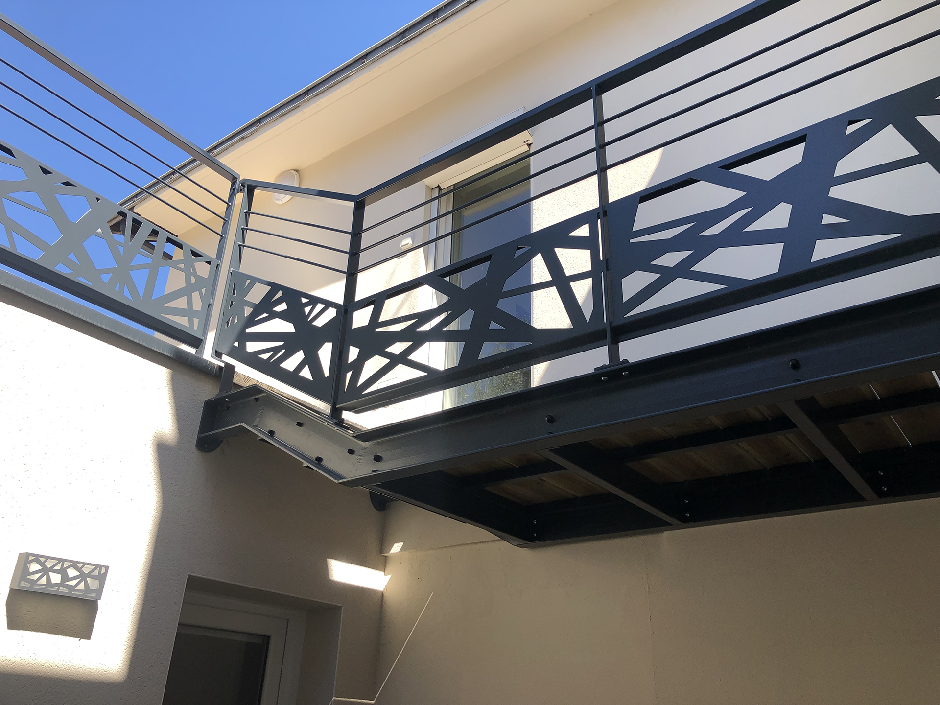 Garde-corps d’escalier intérieur en métal noir avec motifs géométriques croisés