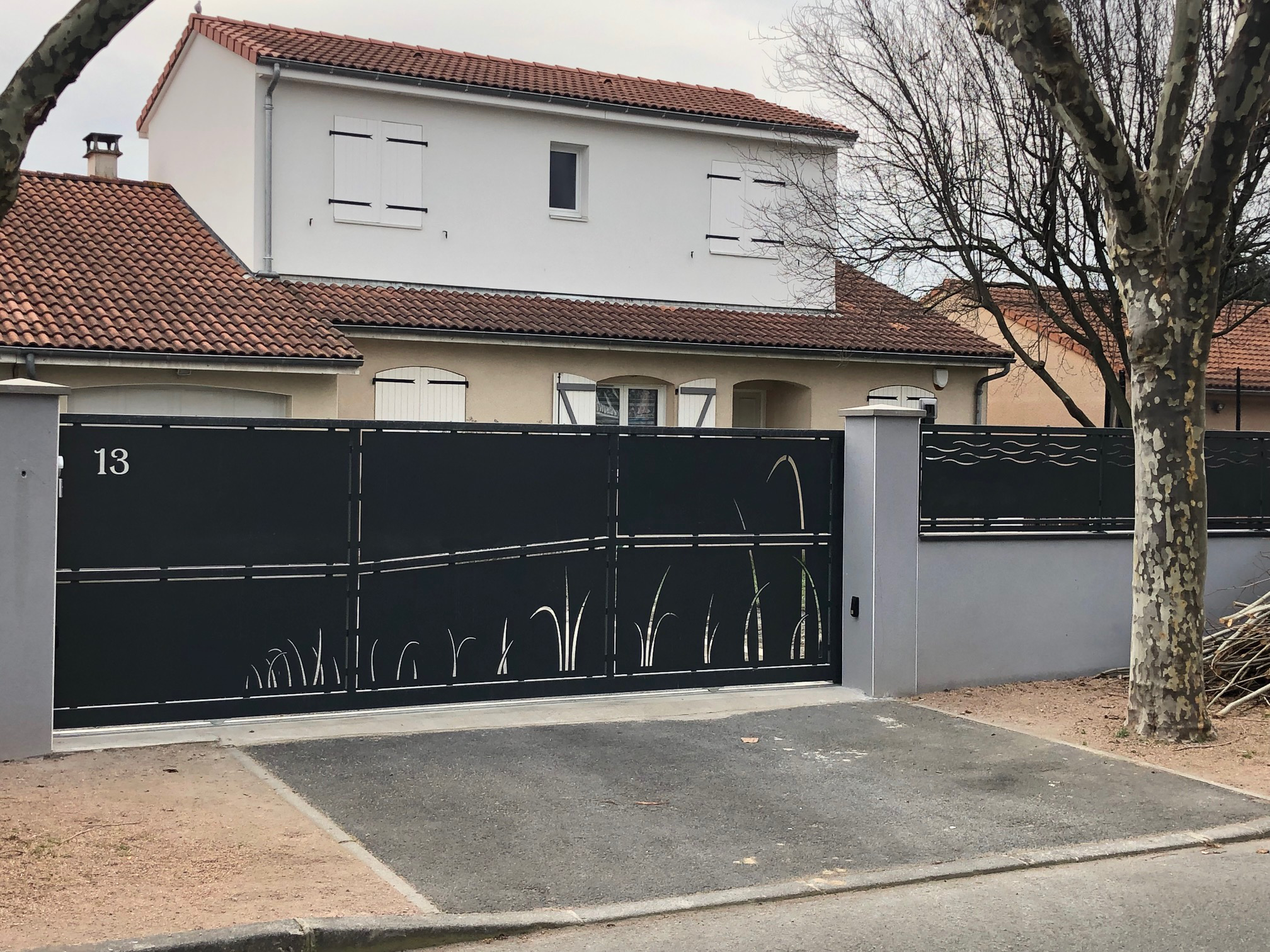 Portail coulissant noir en métal avec décorations ajourées