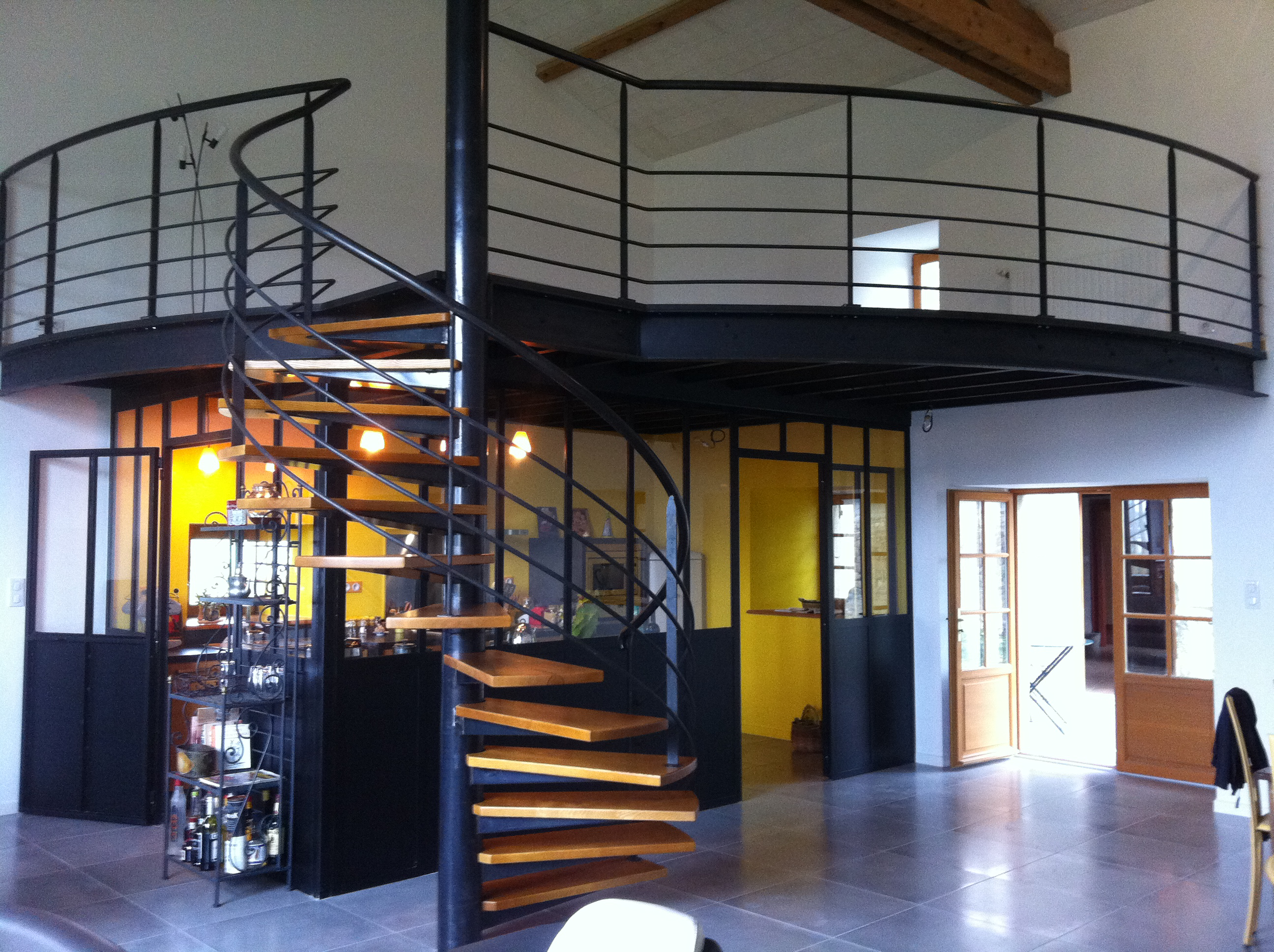 Mezzanine métallique sur mesure avec escalier en colimaçon, garde-corps et cloison intérieure en verrière